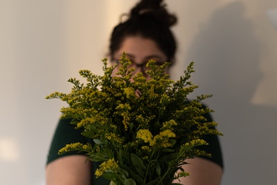 Wearing dark glasses, a handheld green plants
